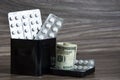 Paid medicine. Tablets and dollars in a tin can. Health care concept and health system. High medical costs and expensive treatment Royalty Free Stock Photo