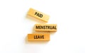 Paid menstrual leave symbol. Concept words Paid menstrual leave on wooden blocks. Beautiful white table white background. Business