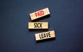 Paid sick leave symbol. Concept words Paid sick leave on wooden blocks. Beautiful black table black background. Business medical