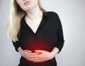 A woman holds on to his stomach. Pain in the abdominal cavity. The concept of diseases of the stomach and digestive system