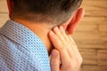 Pain behind ear in area of mastoid process concept photo. Person holds his hand over area behind ear, where pain is suspected due Royalty Free Stock Photo