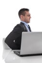 Pain: businessman sitting with backache at desk isolated on whit