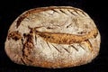 Loafs or miche of French sourdough, called as well as Pain de campagne, on display isolated on a black background.