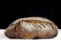 Loaf or miche of French sourdough, called as well as Pain de campagne, on display on a black and white background.