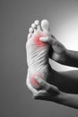 Pain in the foot. Massage of female feet. Pain in the human body on a gray background
