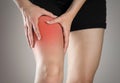 Pain in the leg of a woman. Highlighted in red. On a gray background. Close up Royalty Free Stock Photo