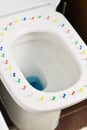 Pain and other symptoms of external hemorrhoids, abstract image with toilet bowl and colorful thumbtacks on his cover
