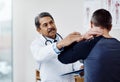 The pain is right behind my neck. a confident mature male doctor doing a checkup on a patient inside of a hospital Royalty Free Stock Photo