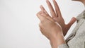 Pain and snapping fingers. Female hand tries to stretch fingers out and click her joints on white background. Close-up