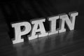 Pain, text words typography written with wooden letter on black background, life and business negativity