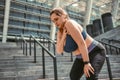 Pain after workout. Young plus size woman touching her shoulder and feeling pain after sport training while standing on Royalty Free Stock Photo