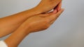 Pain in wrist. Female hand touches wrist and tries to stretch joint. Tendinitis, synovitis, osteoarthritis, sprain