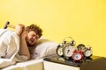 Man wakes up and he& x27;s mad at clock ringing, switches it off with the hammer Royalty Free Stock Photo