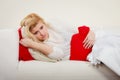 Woman feeling stomach cramps lying on cofa Royalty Free Stock Photo