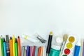 Variety of colorful pencils, paints, markers on white background