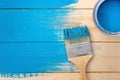 Paint brush in blue paint lies on the boards that are not completely painted over near an open can of blue paint Royalty Free Stock Photo