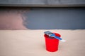 Paint brush and a bucket with paint next to a building exterior wall. Painting house plinth outside. Home renovation. Nobody Royalty Free Stock Photo