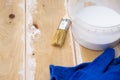 Paint brush and a can with white paint on the boards, preparing a wooden surface for painting concept