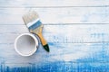 Paint brush with a can of a white paint on the wooden boards painted in blue and white paint Royalty Free Stock Photo