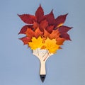 Paint brush with dry bright autumn leaves concept