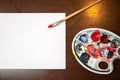 Paint brush laying on white black paper on wooden table. Copy space for text Royalty Free Stock Photo