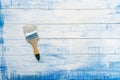Paint brush lying on the wooden boards painted in blue and white paint Royalty Free Stock Photo