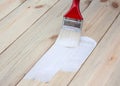 Paint brush paints wooden boards with white paint Royalty Free Stock Photo