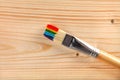 Paint brush with rainbow strokes on bristle on wooden background Royalty Free Stock Photo