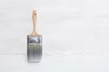 Paint brush on white wall background. Home improvement, construction, enhancing or renovating home, setting up new homes