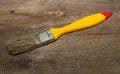 Paint brush width 1 inch with yellow handle on a wooden background Royalty Free Stock Photo