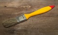 Paint brush width 1 inch with yellow handle on a wooden background Royalty Free Stock Photo