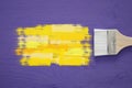 paint brush and yellow stroke on purple background