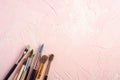 Paint brushes, artist tools for drawing on textured pink background