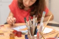 Paint brushes on blur background of paint and a girl is engaged in painting. gouache painting