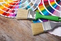 Paint brushes and color palette samples on wooden background Royalty Free Stock Photo