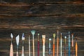 Paint brushes on a dark wooden background, top view. Concept of Royalty Free Stock Photo