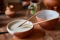 Paint brushes dip in ceramic bowl on worktop in a potter workshop, close-up, selective focus. Royalty Free Stock Photo