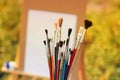 Paint brushes on an easel background with paints