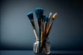 Paint brushes in a glass jar on a dark blue background. Royalty Free Stock Photo