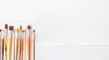 Paint brushes on white background. A row of colorful paint brushes with wooden handles and different types of bristles Royalty Free Stock Photo