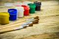 Paint brushes and a white sheet of paper. Composition of watercolor and gouache paints on a wooden background. Royalty Free Stock Photo