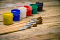 Paint brushes and a white sheet of paper. Composition of watercolor and gouache paints on a wooden background. Royalty Free Stock Photo