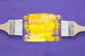 paint brushes and yellow stroke on purple background