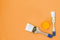 Paint can and brush on orange background. House renovation concept. Set of tools and paints for making repair in flat Royalty Free Stock Photo