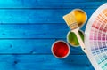 Paint cans color palette, cans opened with brushes on blue table Royalty Free Stock Photo