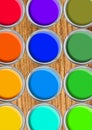 Paint cans color palette, cans opened top view on wooden table