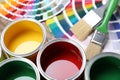 Paint cans, color palette samples and brushes on table Royalty Free Stock Photo