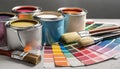 Paint cans, color palette samples and brushes on table Royalty Free Stock Photo