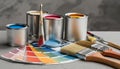 Paint cans, color palette samples and brushes on table