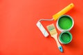 Paint cans with roller and brush on color background Royalty Free Stock Photo